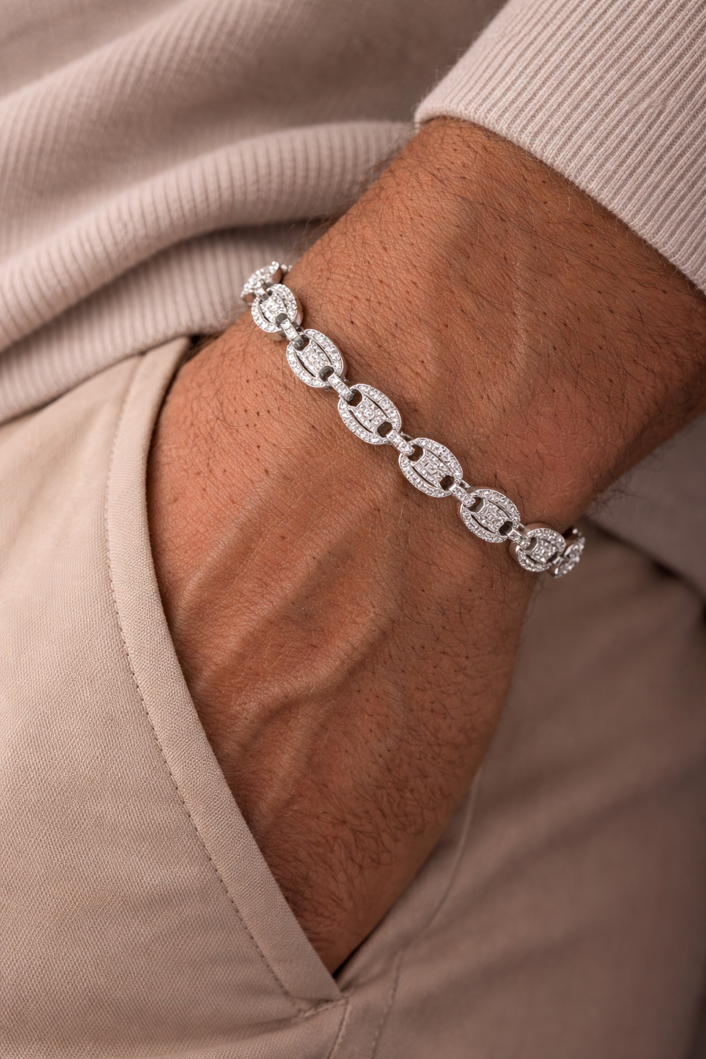 Silver bracelet on a wrist with a neutral background