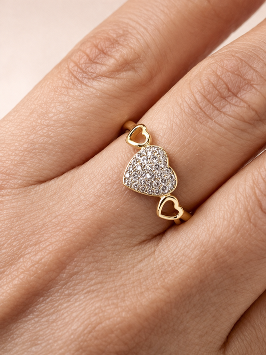 Gold ring with a heart-shaped diamond pendant on a hand