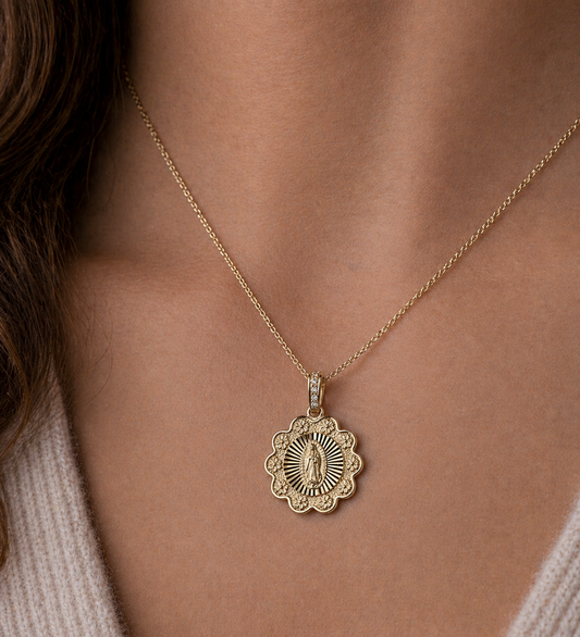 Gold necklace with a decorative pendant on a person's neck