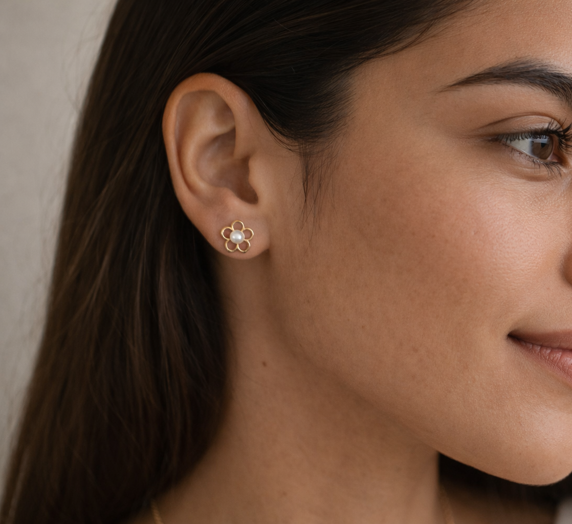 Close-up of a woman wearing a floral earring with a neutral background