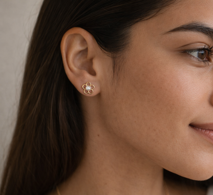 Close-up of a woman wearing a floral earring with a neutral background