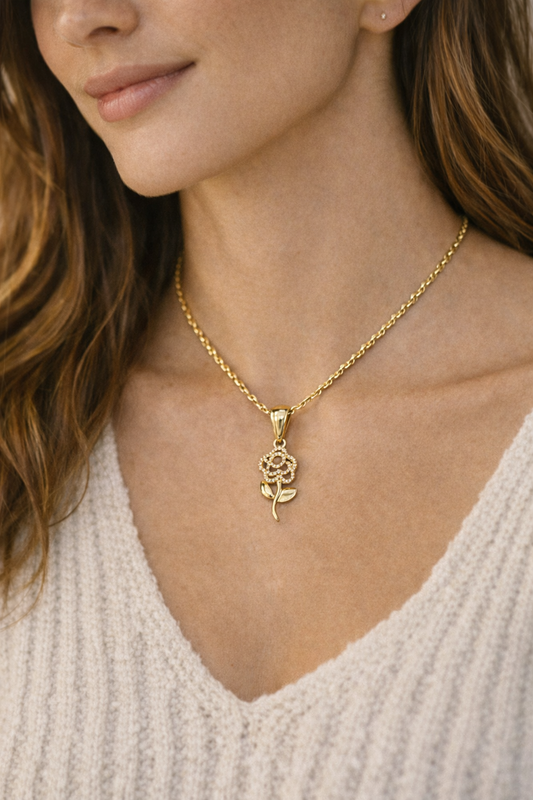 Gold necklace with a rose pendant worn by a person