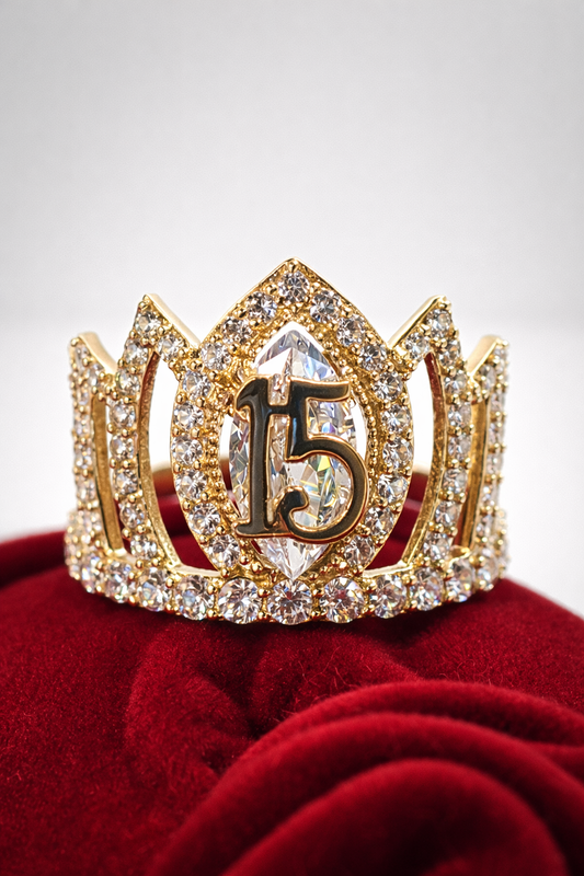 Gold tiara with number 15 on a red cushion against a light gray background