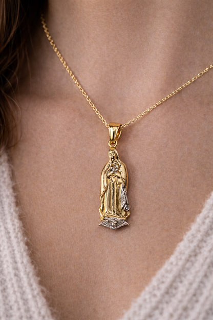 Gold necklace with a religious pendant worn by a person