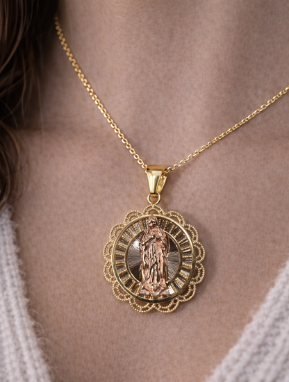 Gold necklace with a detailed pendant on a person wearing a white sweater.