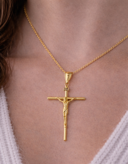 Gold crucifix necklace on a person wearing a white sweater