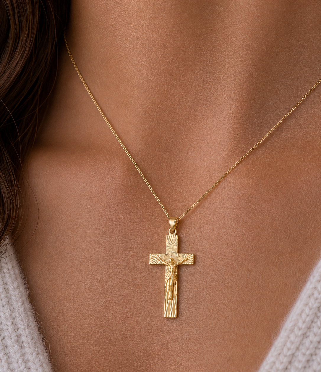 Gold crucifix necklace on a person's neck