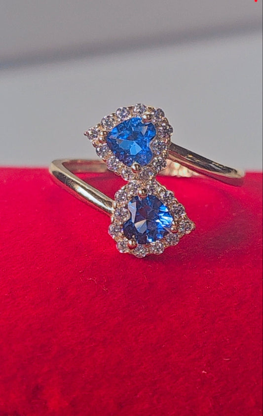 Gold ring with blue gemstones on a red cushion