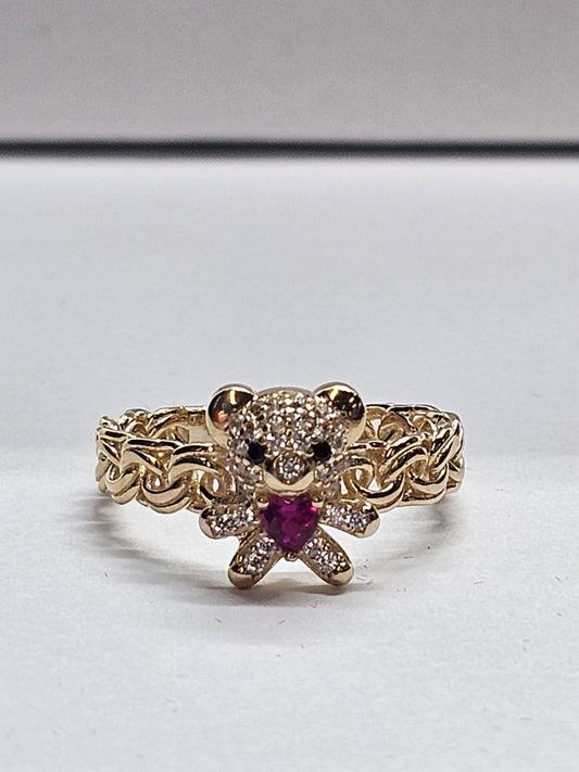 Gold ring with a red gemstone on a white background